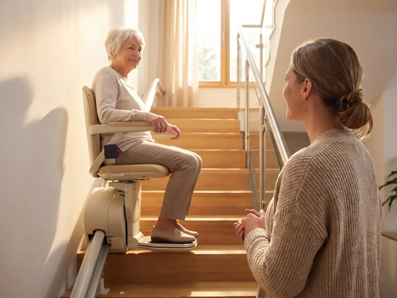 Woman using a modern stairlift at home while speaking with a family member