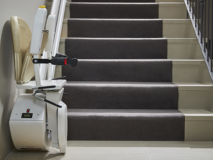 straight stairlift in the folded position at the bottom of the stairs on the left hand side